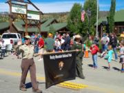 A thumb nail view of Grand Lake, Colorado during Constitution Week in September looking at two (2) Park Rangers carrying the Rocky Mountain National Park Banner in the Parade; click here to open a window with a larger picture.